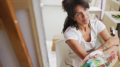 Biracial-woman-paints-in-a-bright-studio