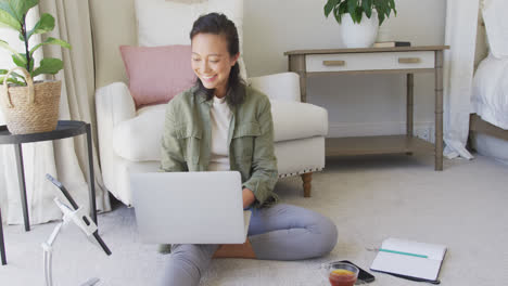 Glückliche-Asiatische-Frau-Mit-Laptop-Und-Tablet-Im-Schlafzimmer,-In-Zeitlupe