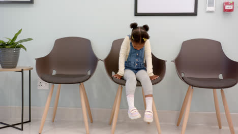 African-american-girl-sitting-in-hospital-waiting-room-with-copy-space,-slow-motion