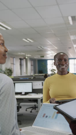 Vertical-video-of-happy-african-american-business-people-discussing-work-in-slow-motion