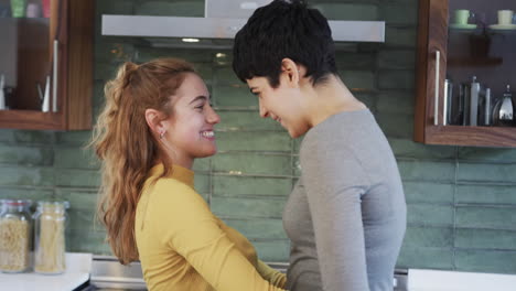 Feliz-Pareja-De-Lesbianas-Caucásicas-Abrazándose-Y-Bailando-En-La-Soleada-Cocina