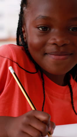 Vertical-video-of-an-African-American-girl-focuses-on-her-schoolwork-at-home