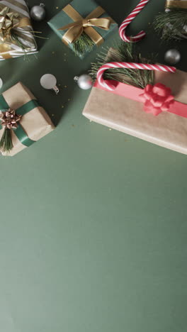 Vertical-video-of-christmas-presents-and-copy-space-on-green-background