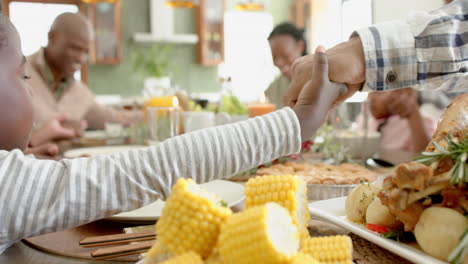 Glückliche-Afroamerikanische-Mehrgenerationenfamilie,-Die-Beim-Thanksgiving-Dinner-Händchen-Hält,-Zeitlupe