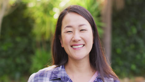 Video-of-portrait-of-happy-asian-woman-posing-in-garden