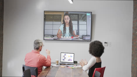 Diverse-business-people-on-video-call-with-caucasian-female-colleague-on-screen