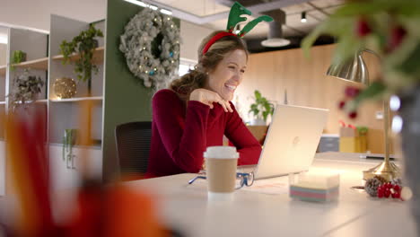 Feliz-Mujer-De-Negocios-Caucásica-Casual-Con-Sombrero-De-Reno-Haciendo-Videollamadas-En-Navidad,-Cámara-Lenta