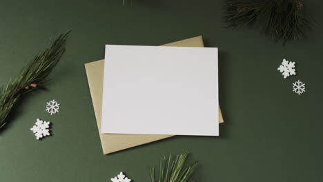 Video-of-christmas-decorations-and-white-card-with-copy-space-on-green-background