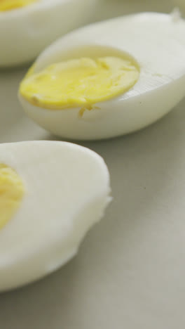 Video-of-close-up-of-halves-of-hard-boiled-eggs-on-grey-background