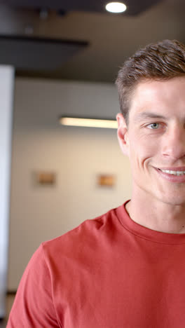 Vertical-video-of-portrait-of-happy-caucasian-businessman-in-office-in-slow-motion