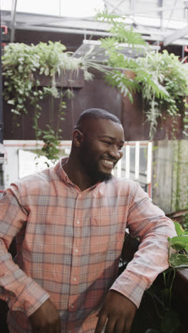 Happy-african-american-casual-man-looking-ahead,-smiling,-waving,-and-looking-at-camera,-slow-motion