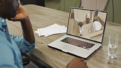 African-american-man-at-table-using-laptop,-online-shopping-for-beauty-products,-slow-motion