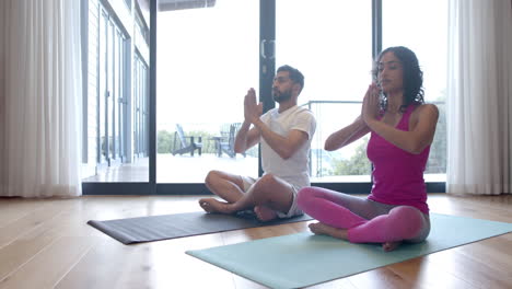 Pareja-Birracial-Haciendo-Yoga-Y-Meditando-En-Casa,-En-Cámara-Lenta