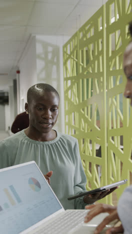 Vertical-video-of-happy-african-american-businesswomen-using-tablet-in-slow-motion