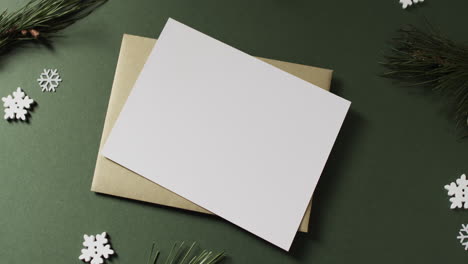 Video-of-christmas-decorations-and-white-card-with-copy-space-on-green-background