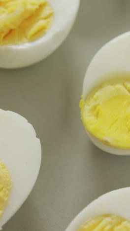 Video-of-close-up-of-halves-of-hard-boiled-eggs-on-grey-background