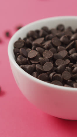 Video-of-bowl-of-chocolate-chip-over-pink-background