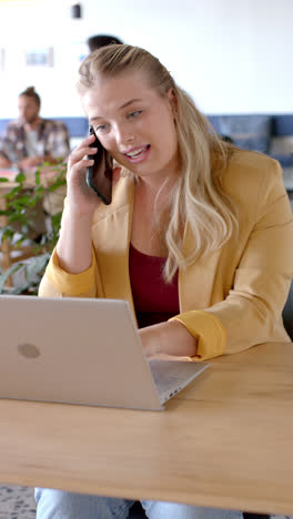 Vertical-video-of-happy-diverse-business-people-talking-on-smartphone-in-office-in-slow-motion