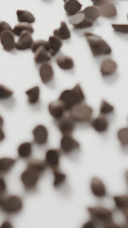 Video-of-close-up-of-multiple-chocolate-chip-over-white-background