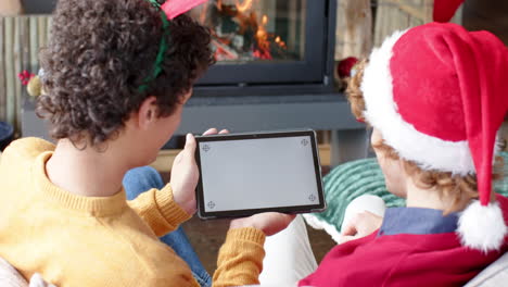 Diverse-gay-male-couple-using-tablet-with-copy-space-on-screen-for-video-call-at-home,-slow-motion