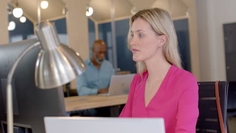 Caucasian-businesswoman-using-laptop-in-office-with-copy-space