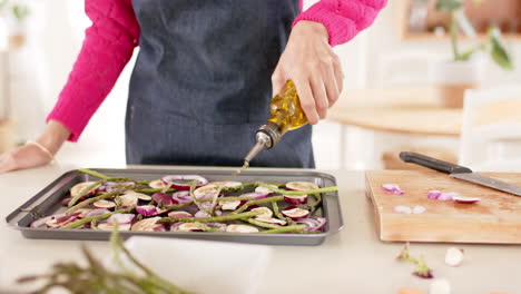 Mid-section-of-biracial-woman-preparing-food-in-kitchen-at-home-with-copy-space,-slow-motion