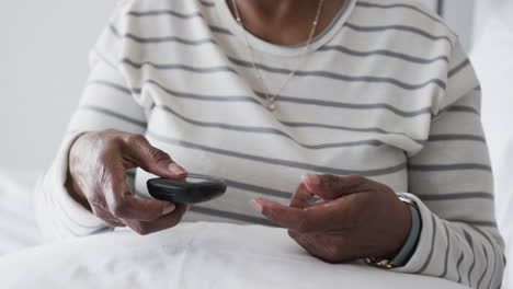 Senior-african-american-woman-checking-blood-pressure,-slow-motion