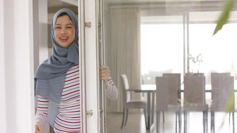 Retrato-De-Una-Mujer-Birracial-Sonriente-Con-Hijab-En-Casa-Con-Espacio-Para-Copiar,-Cámara-Lenta