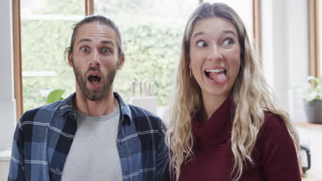 Portrait-of-happy-diverse-couple-in-kitchen-at-home,-in-slow-motion