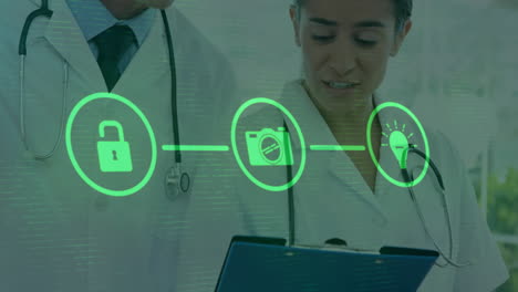 Animation-of-flowchart-of-icons-over-diverse-doctors-over-discussing-patients-reports-in-hospital