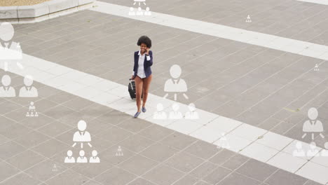 Animation-of-flowcharts,-african-american-woman-walking-with-trolley-bag-and-talking-on-cellphone