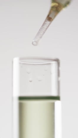 Vertical-video-of-laboratory-pipette-and-test-tube-with-copy-space-on-white-background