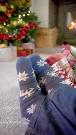 Vídeo-Vertical-De-Pies-De-Familia-En-Chimenea-De-Calcetines-Calientes-En-Navidad,-Espacio-De-Copia,-Cámara-Lenta