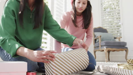 Montage-of-happy-biracial-mother-and-adult-daughter-at-home-together-at-christmas,-slow-motion