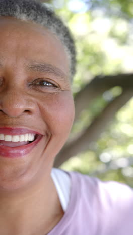 Vertical-video-half-portrait-of-happy-african-american-woman-in-sunny-nature,-slow-motion