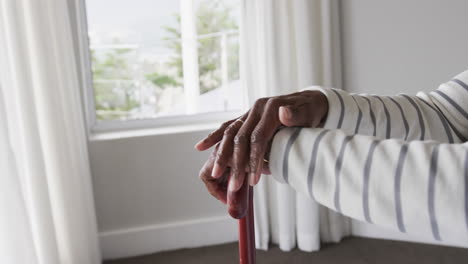 Mid-section-of-senior-african-american-woman-with-walking-stick,-copy-space,-slow-motion