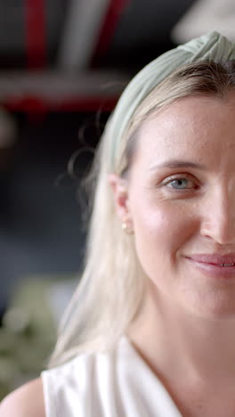 Vertical-video-of-portrait-of-smiling-caucasian-businesswoman-in-office-with-copy-space