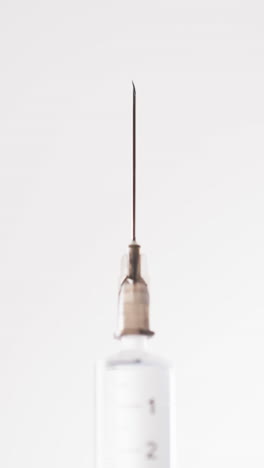 Vertical-video-of-laboratory-syringe-with-copy-space-on-white-background