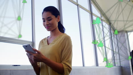 Animation-Von-Verbundenen-Symbolen-Globen-über-Lächelnde-Asiatische-Frau-Scrollen-Auf-Smartphone-Im-Büro