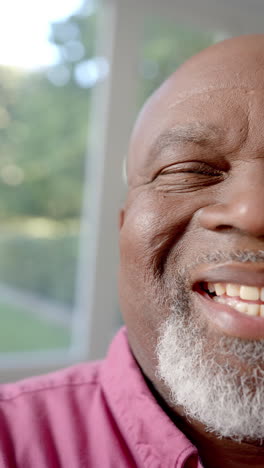 Vídeo-Vertical-Medio-Retrato-De-Un-Feliz-Hombre-Afroamericano-Mayor-Sonriendo-En-Casa,-Cámara-Lenta