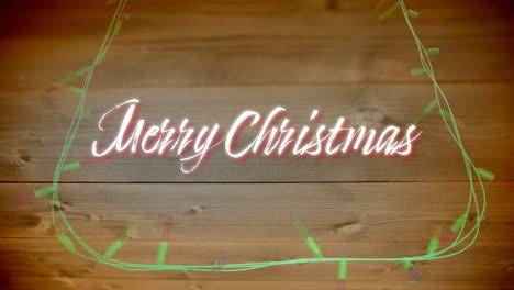 Animation-of-merry-christmas-text-and-fairy-lights-on-wooden-background