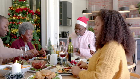 Feliz-Madre-Afroamericana-Sonriendo-En-La-Mesa-De-La-Cena-Navideña-Familiar-De-Varias-Generaciones