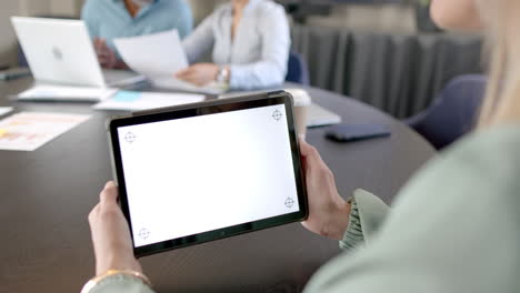 Caucasian-businesswoman-using-tablet-at-conference-table-with-copy-space