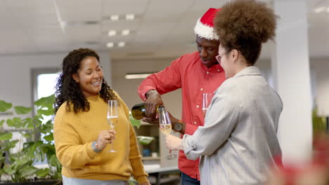 Casual-diverse-businesspeople-drinking-champagne-at-christmas-in-office,-slow-motion