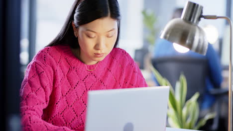 Asian-businesswoman-using-laptop-in-office,-slow-motion,-copy-space