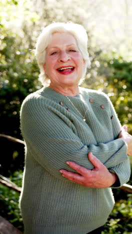 Vertical-video-portrait-of-happy-senior-caucasian-woman-with-white-hair-in-sunny-nature,-slow-motion