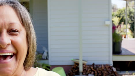 Portrait-of-happy-senior-biracial-woman-smiling-outside-house,-slow-motion,-copy-space