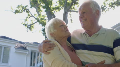 Feliz-Pareja-Caucásica-Mayor-Abrazándose-En-Un-Jardín-Soleado,-Cámara-Lenta