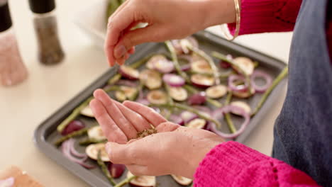 Mid-section-of-biracial-woman-preparing-food-in-kitchen-at-home-with-copy-space,-slow-motion