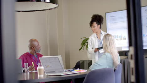 Diverse-doctors-using-laptops-in-meeting-room-with-copy-space,-slow-motion